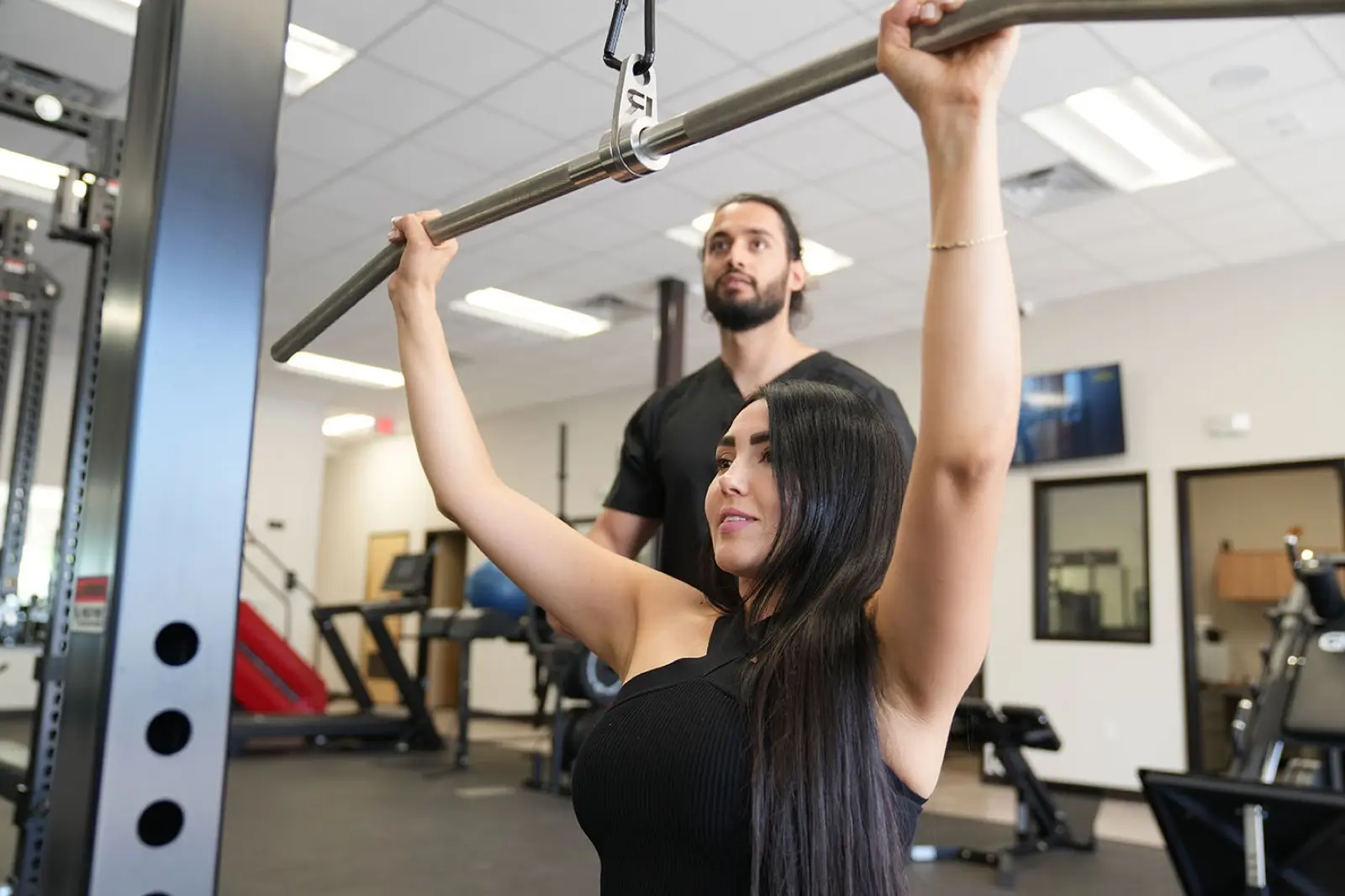 Personal trainer guiding a client through a strength exercise at KM Wellness Center in El Paso
